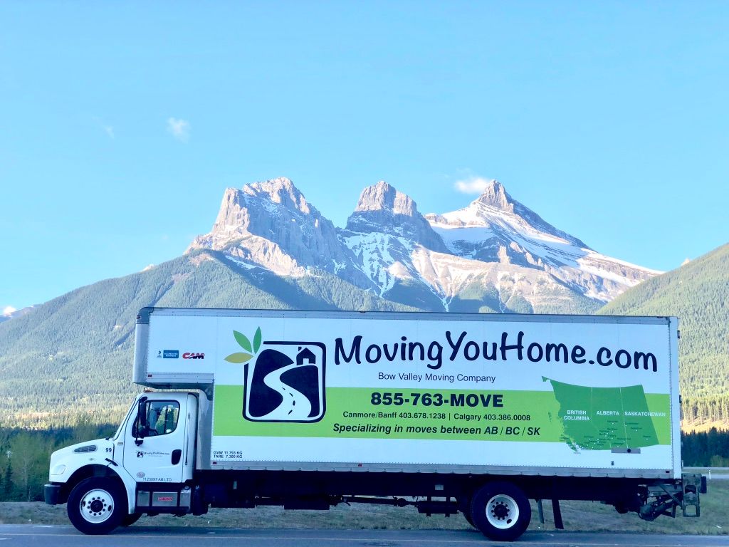 MovingYouHome.com moving truck on a road with mountains in the background