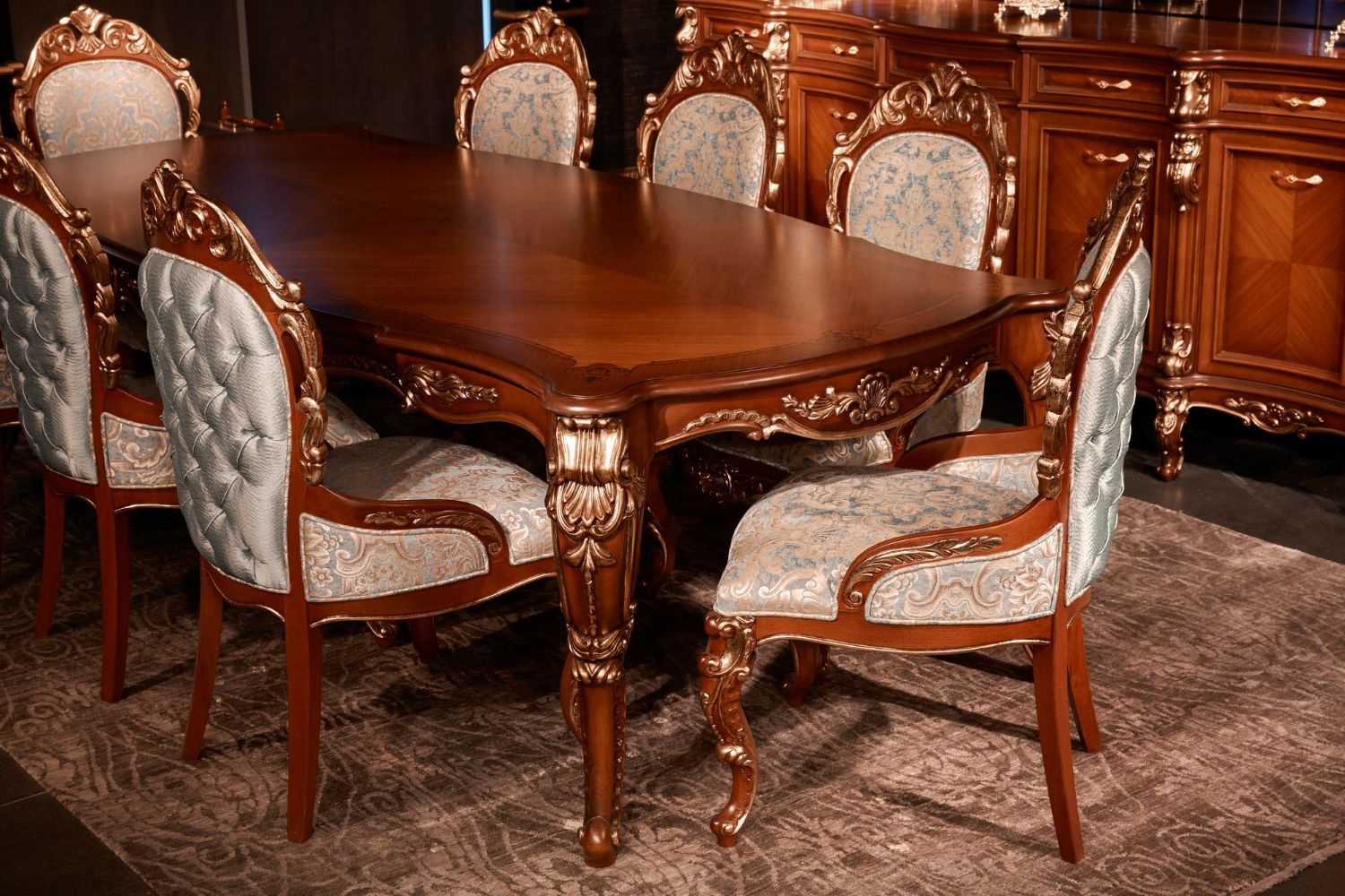 Elegant wooden dining table with carved chairs on a patterned rug