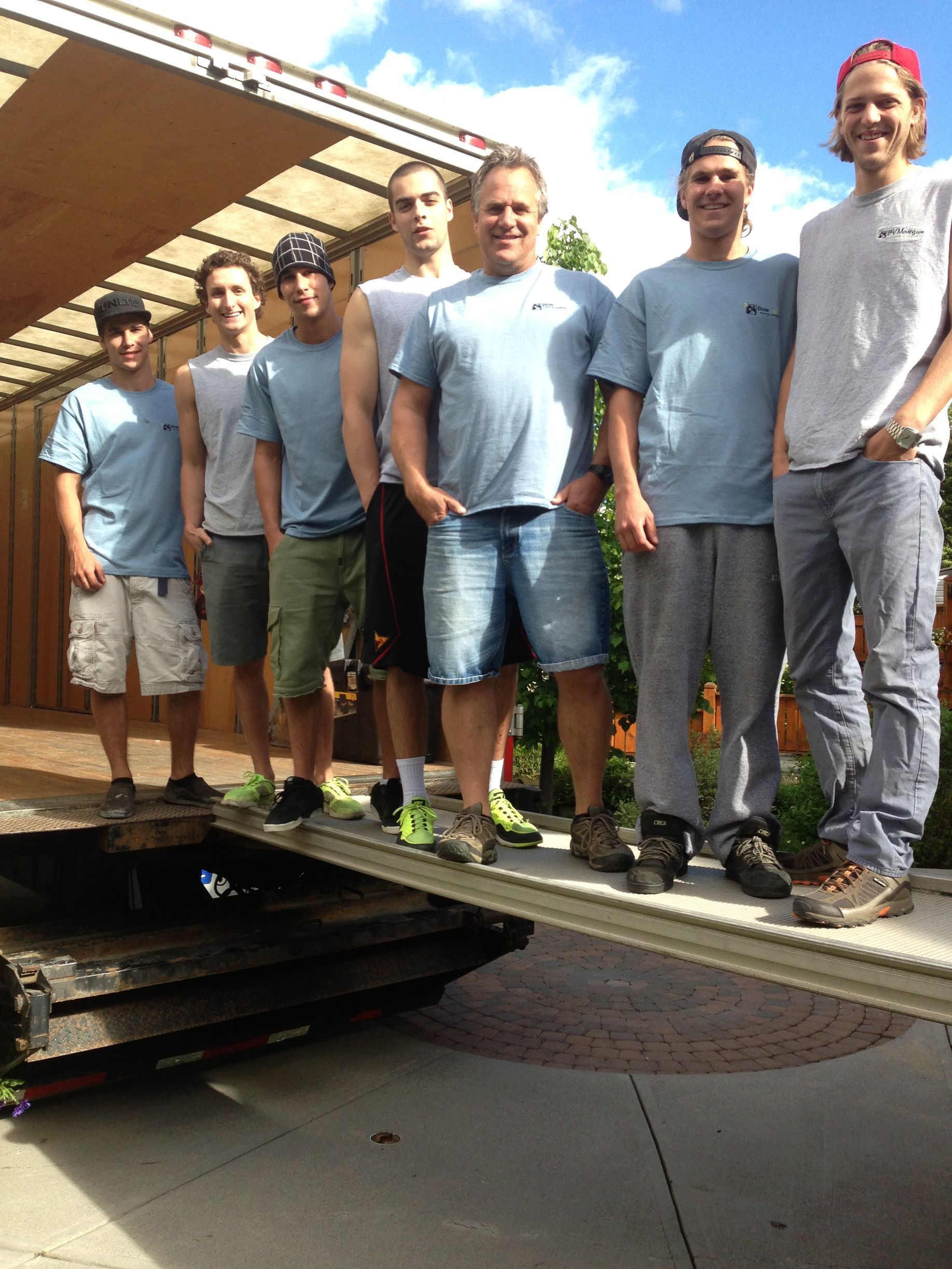 A group of men standing in front of a truck