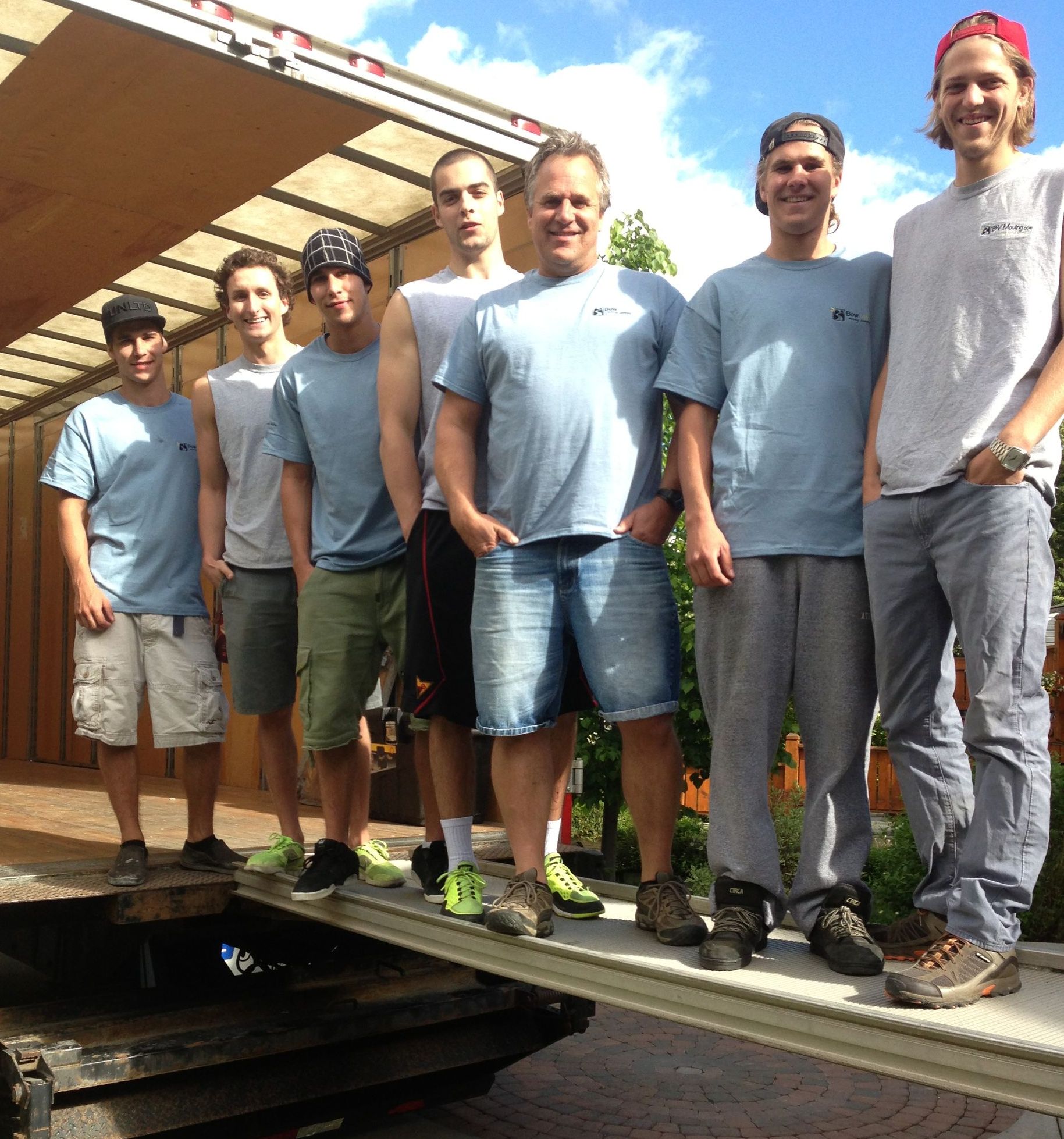 A group of men are posing for a picture in front of a truck