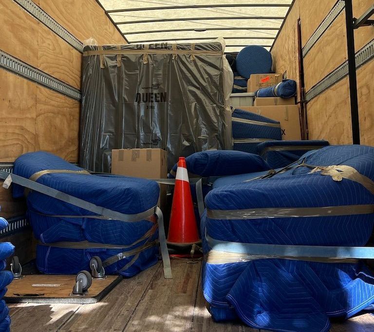 The inside of a moving truck filled with furniture and boxes