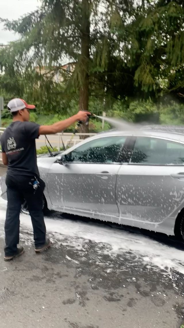A1 technician rinsing a customer's car in their driveway