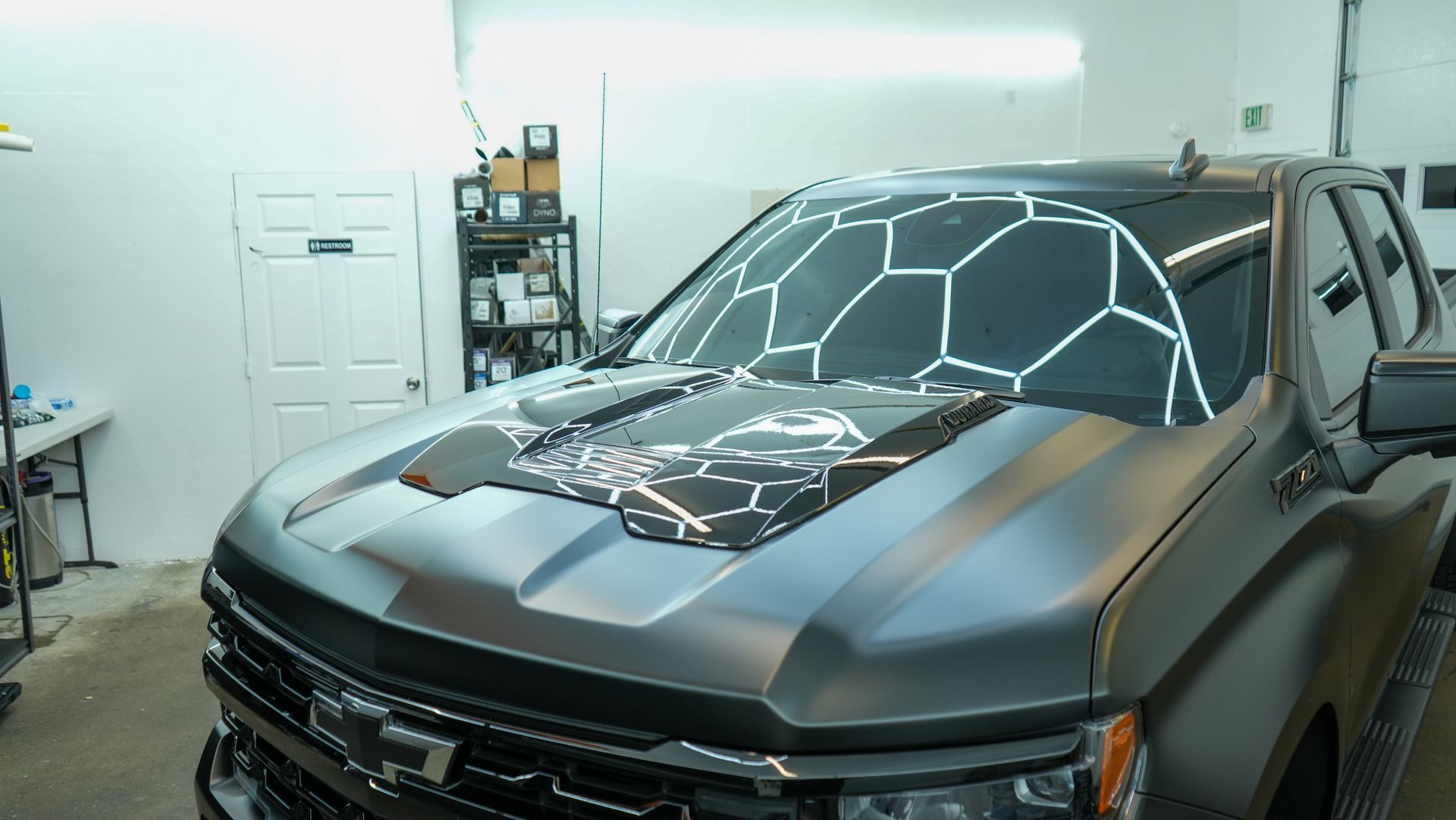 Shop lights reflected in a freshly polished hood