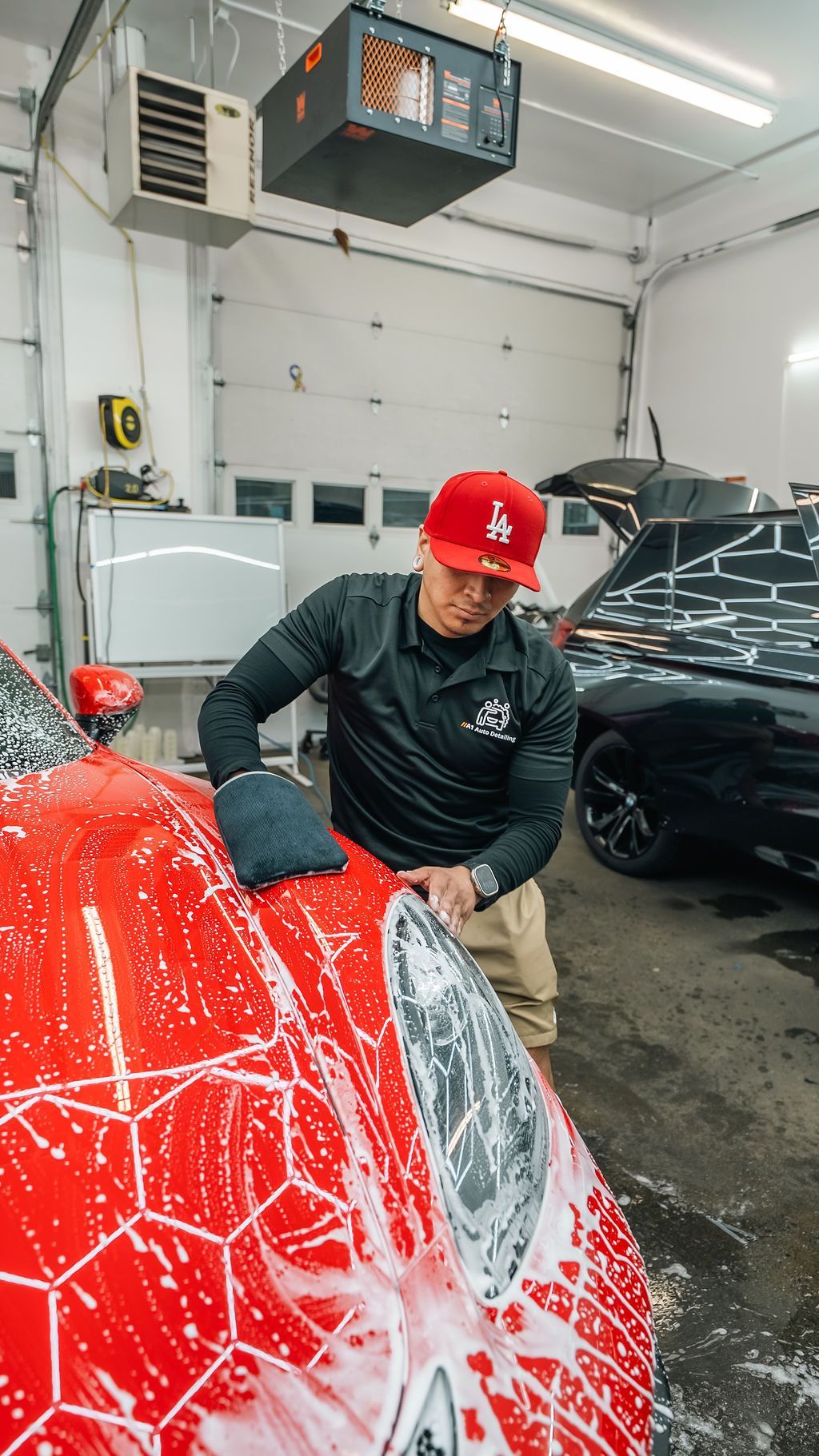 A1 Auto Detailing installer applying STEK paint protection film to a red Porsche in the Lynnwood shop