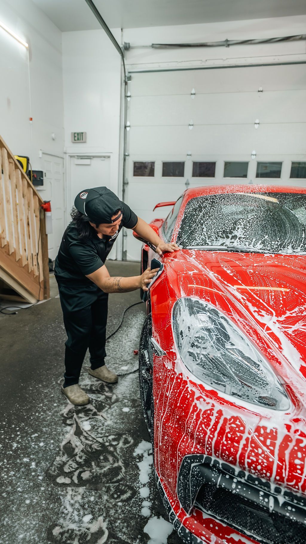 A1 Auto Detailing technician installing paint protection film on a red Porsche GT4