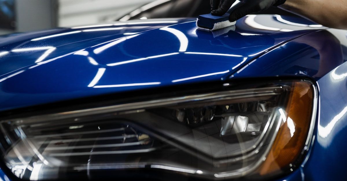 Professional applying ceramic coating in a detailing shop