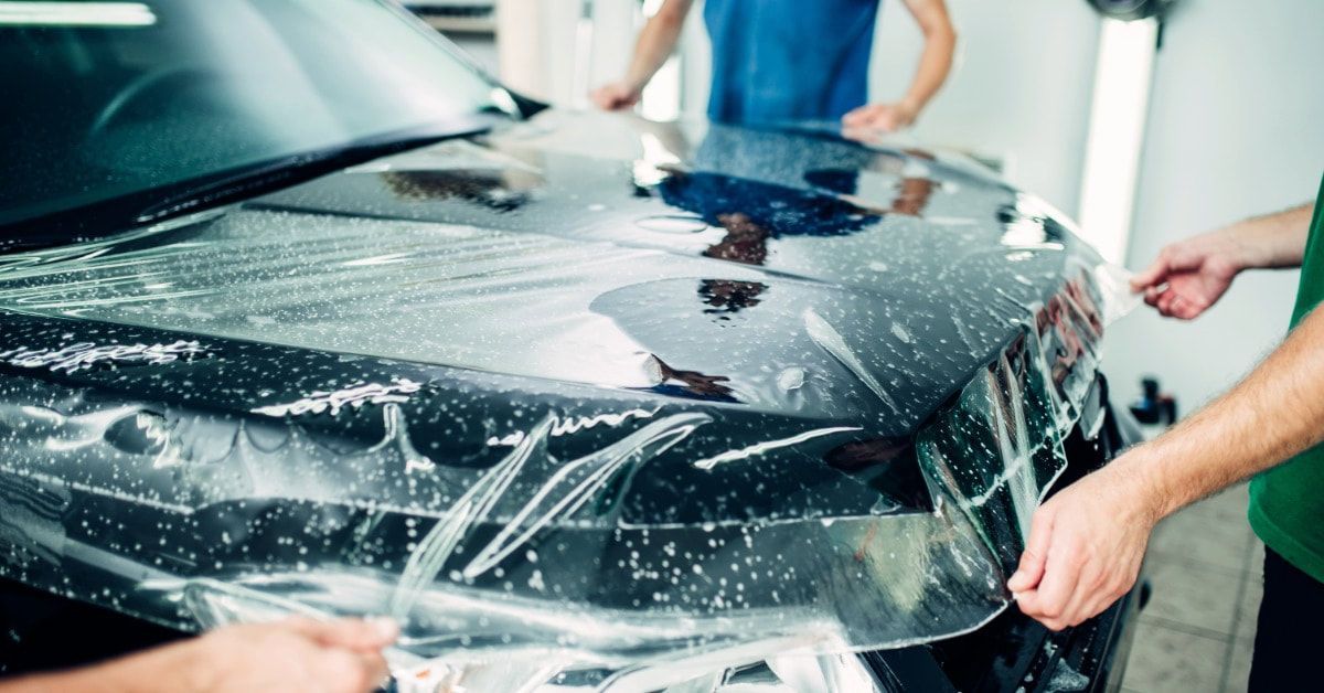 Detailer installing paint protection film on a vehicle