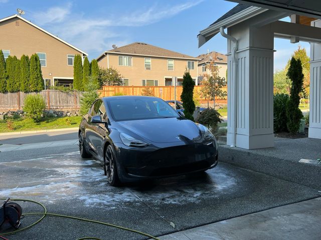 Black SUV freshly washed in a customer's driveway during a mobile detail
