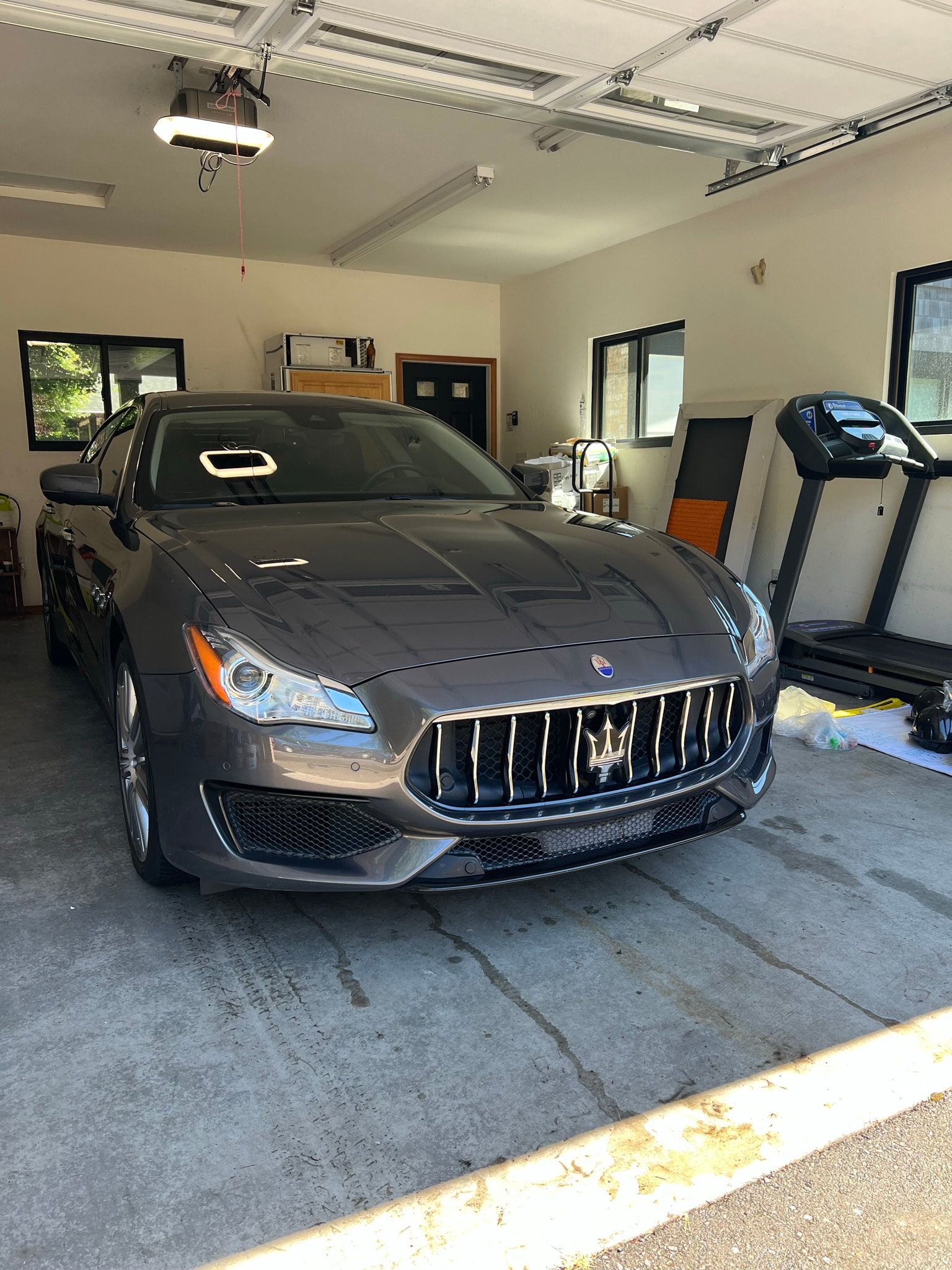 Grey sedan detailed inside a customer's home garage — an enclosed space for coating and paint correction work