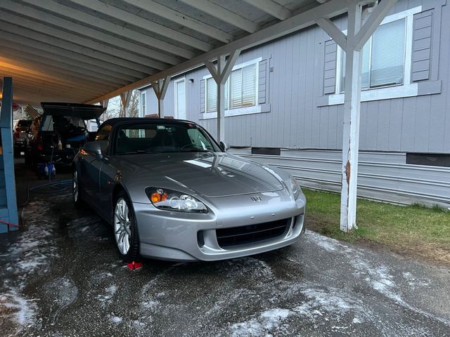 Silver roadster detailed under a customer's carport