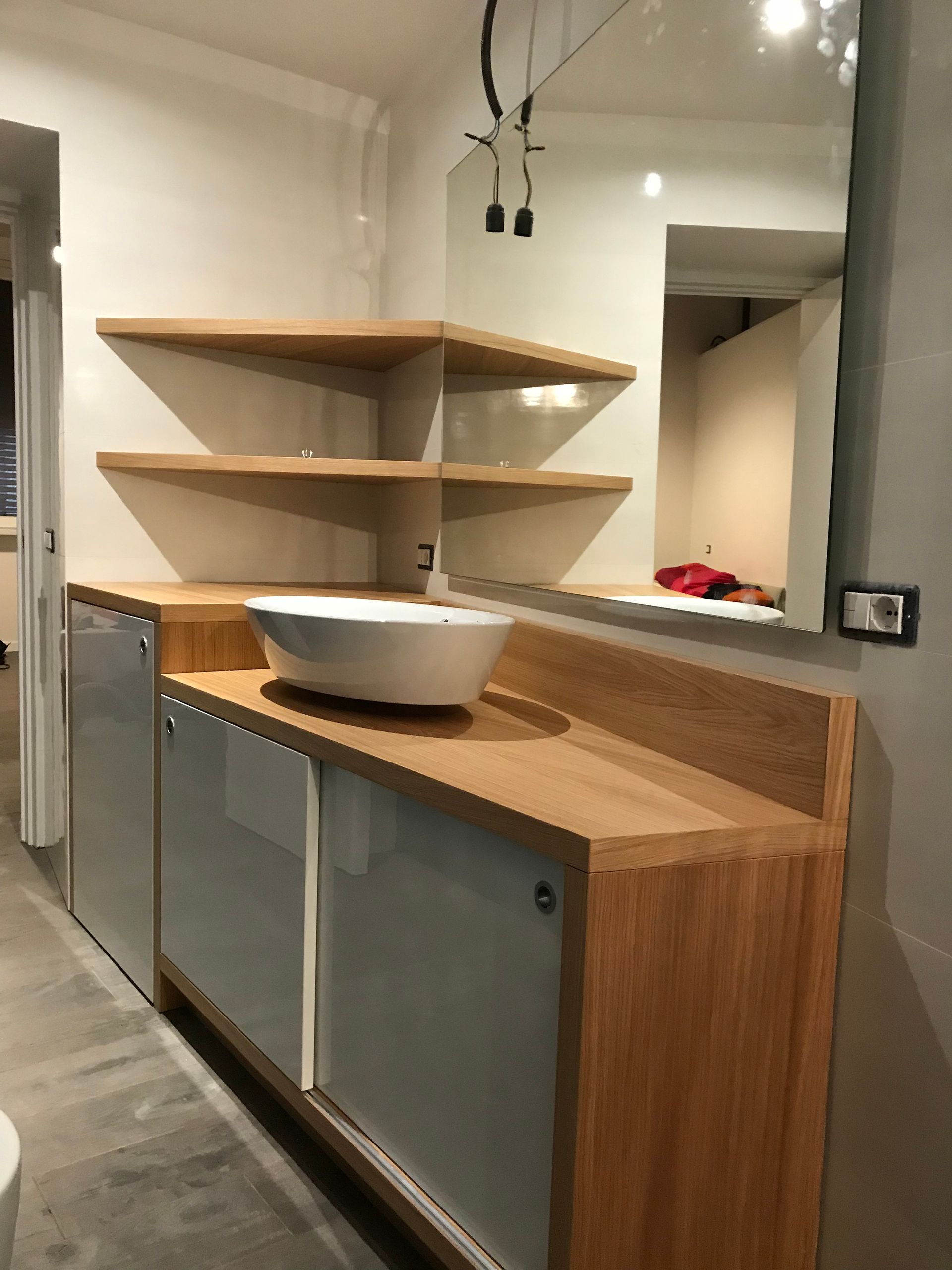 Cucina moderna con isola in legno, lavello, mensole a vista e finestra passavivande.