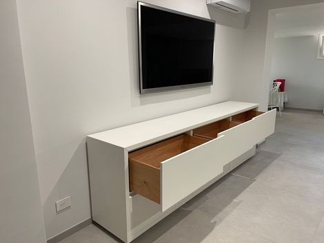 Camera da letto con due letti in legno, lenzuola bianche, quadri alle pareti e un letto a castello in un angolo.