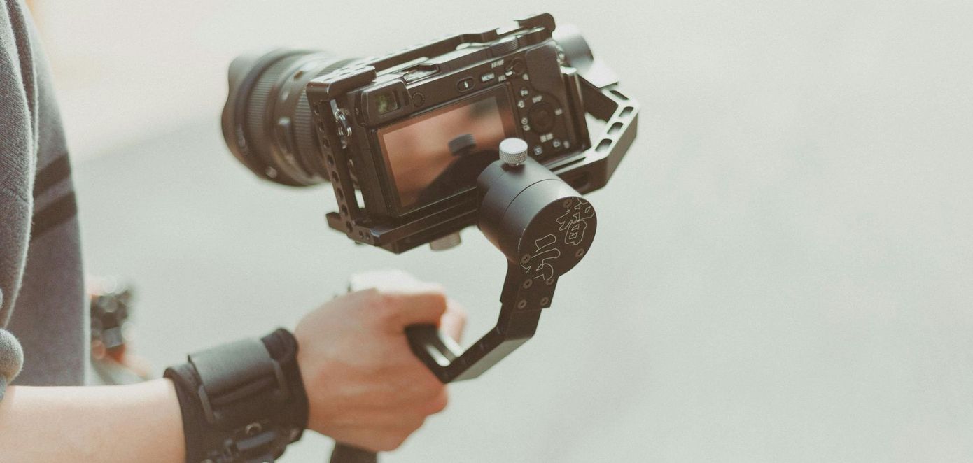 männliche Hand hält Gimbal mit Kamera