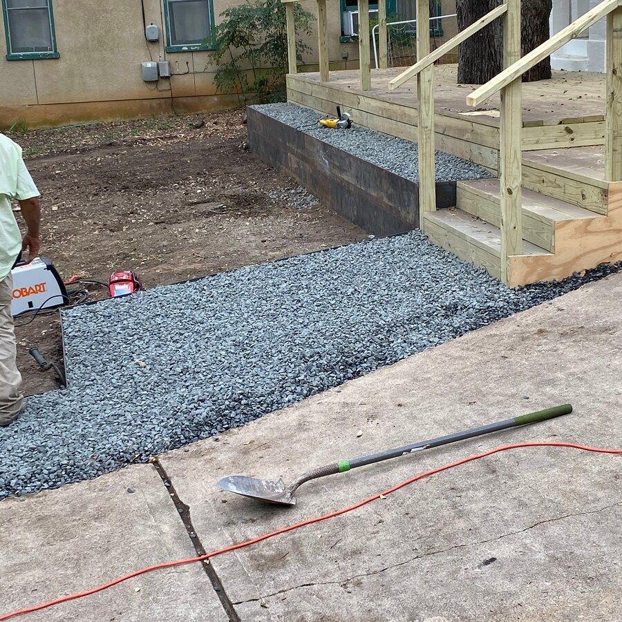 A shovel is laying on the ground next to a staircase