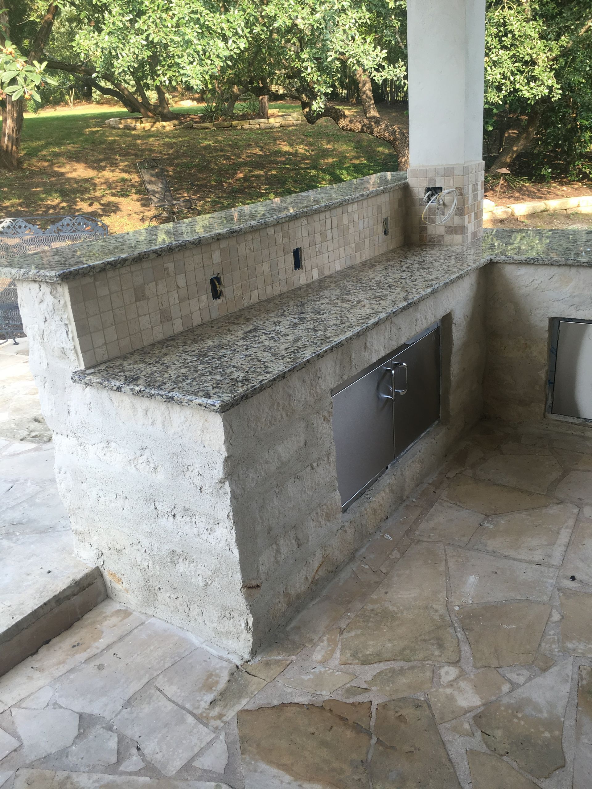 A kitchen with granite counter tops and a stainless steel door