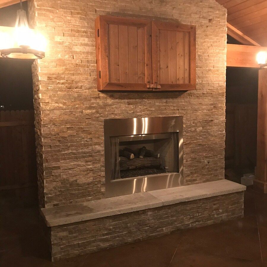 A brick fireplace with a wooden cabinet above it