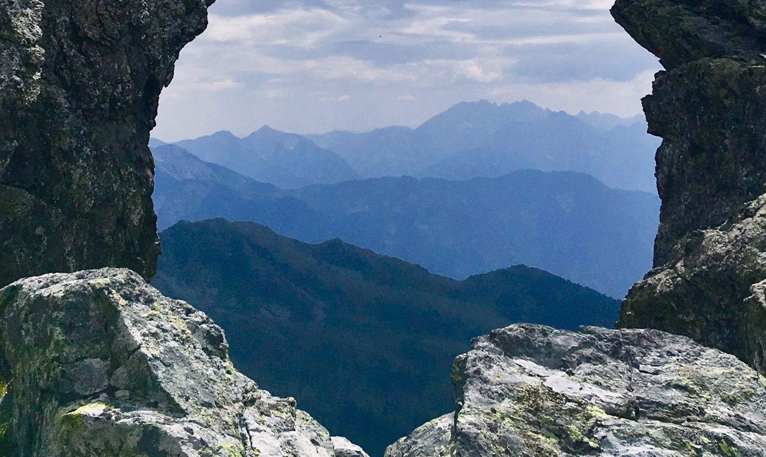 Ein Felsen gibt den Durchblick in die Ferne frei. In der Kreuzeck-Gruppe