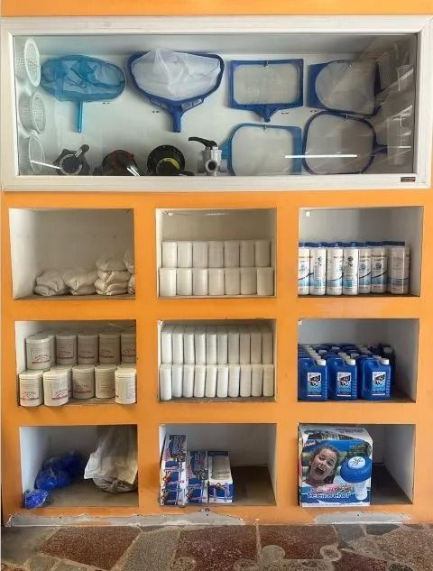 Estantería naranja con artículos de aseo, toallas y productos de papel envasados en contenedores transparentes.