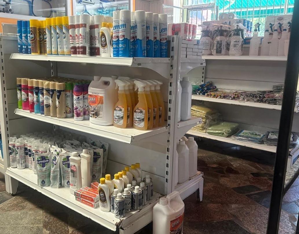Estanterías repletas de botellas y artículos de tocador de diversos tipos en un pasillo de la tienda.