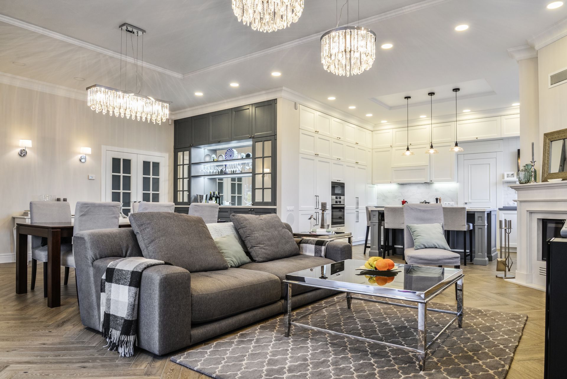 combination living dining and kitchen room with high ceilings and elegant chandelier lighting 