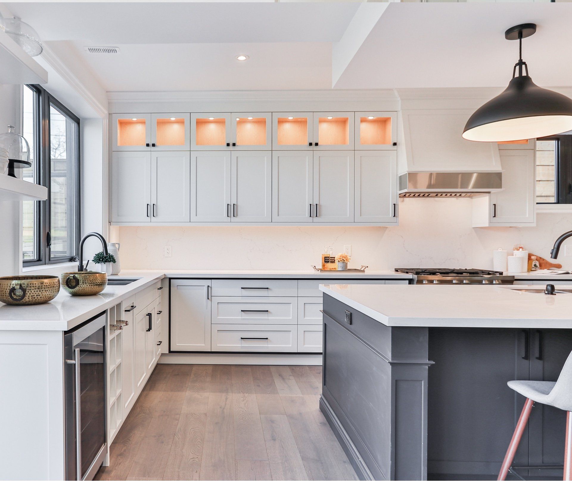 kitchen with white lighted cabinetry and grey island with white quartz counters