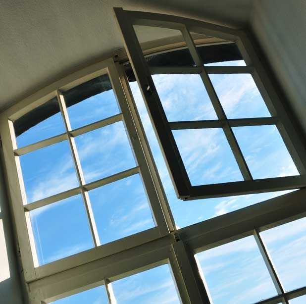 Una ventana abierta con un cielo azul detrás