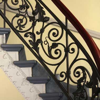Un primer plano de una barandilla de hierro forjado en una escalera.