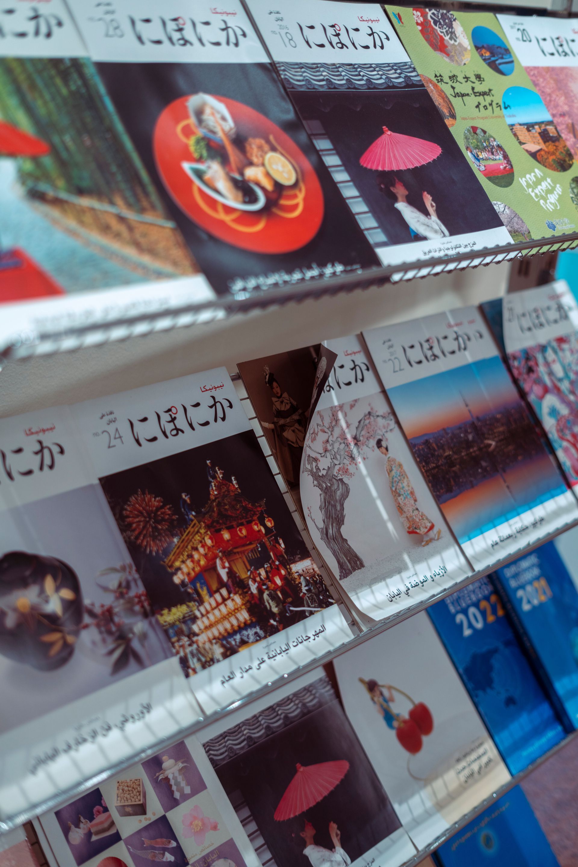 Books and cards displayed on a bookstore shelf, featuring colorful covers and Japanese text