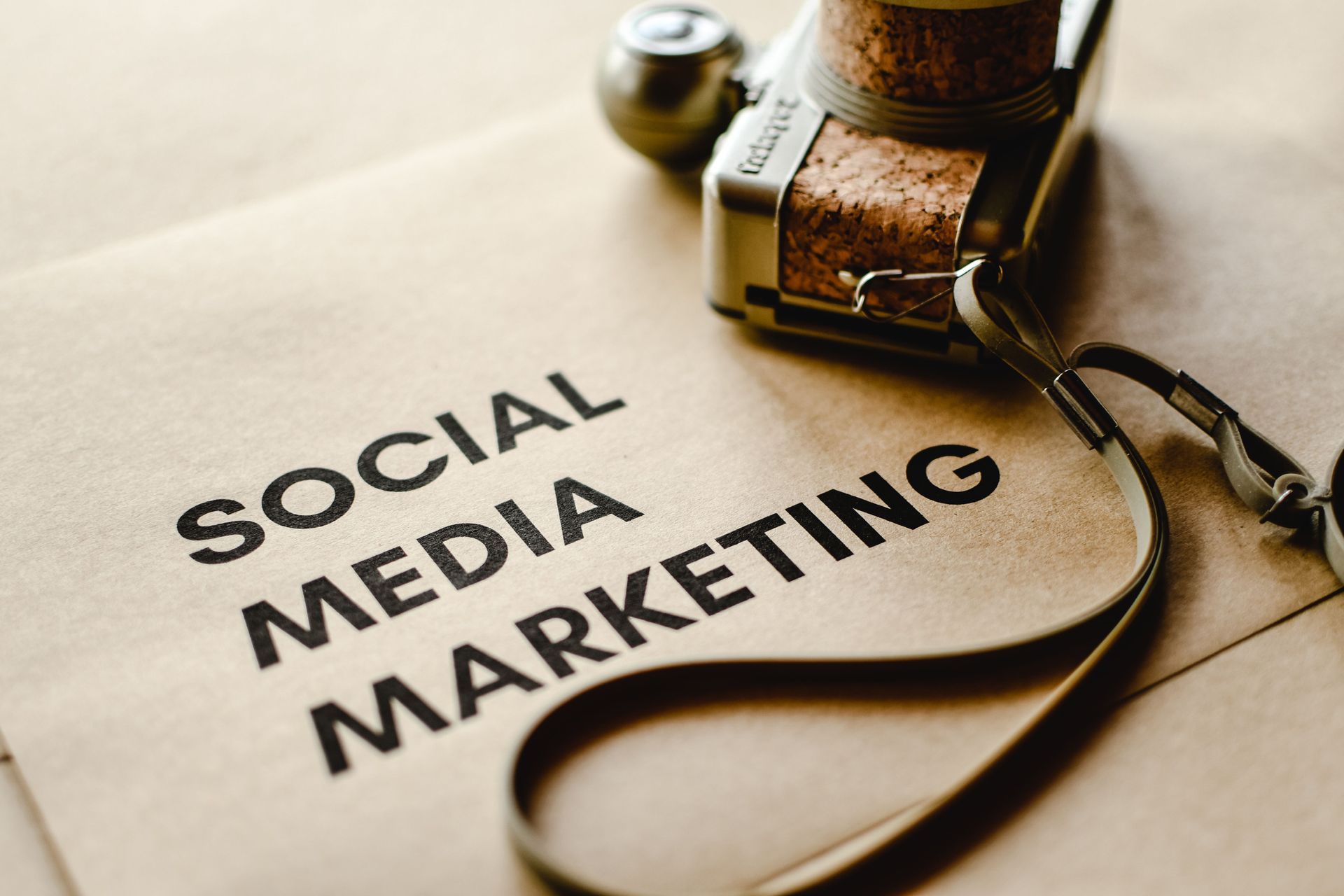 Social media marketing text on paper beside a vintage camera and glasses