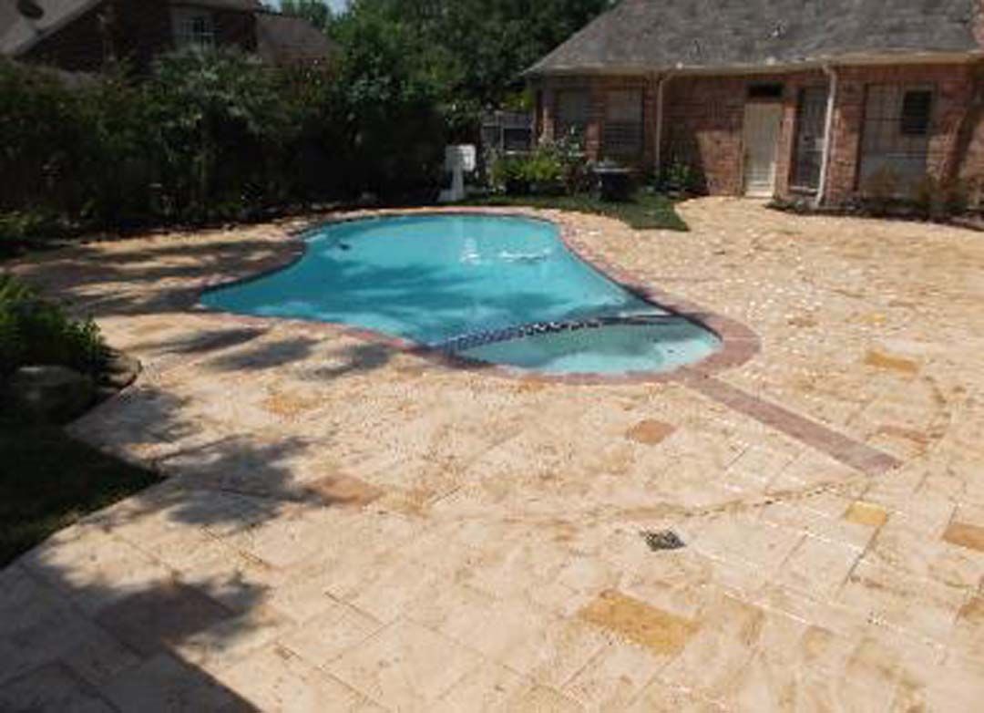 There is a large swimming pool in the backyard of a house.