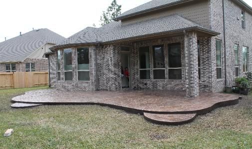 A large brick house with a large patio in front of it.