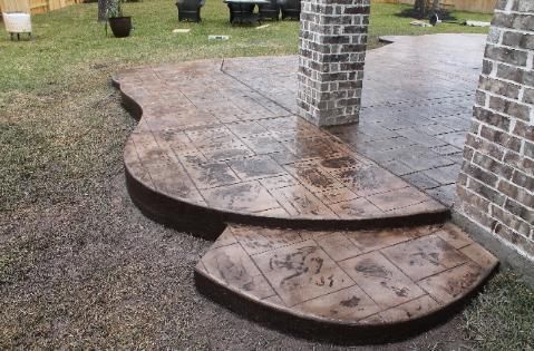 A concrete walkway with steps leading to a brick chimney.