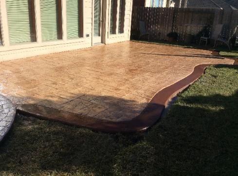 A concrete patio in the backyard of a house.