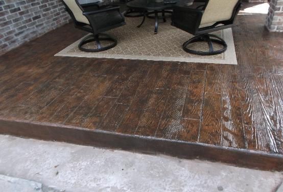 A wooden floor with a rug and chairs on it.