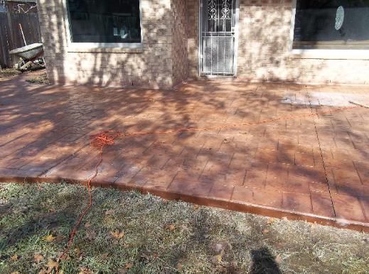 A concrete patio in front of a house with a door.