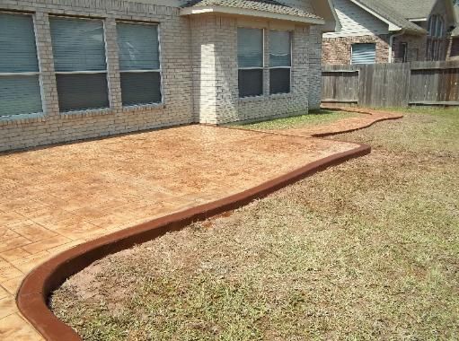 A brick house with a concrete walkway in front of it.