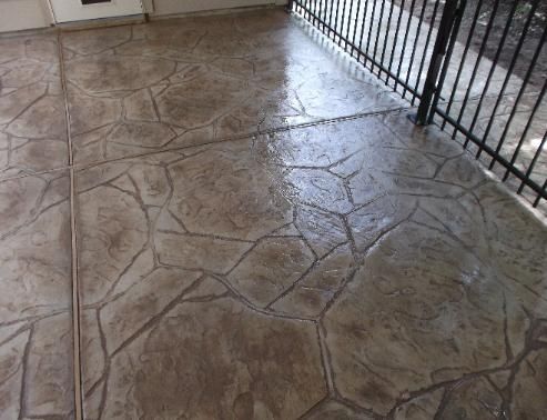 A concrete floor with a fence in the background.