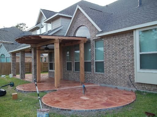 A brick house with a covered patio in front of it