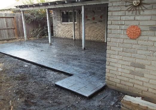 A brick house with a covered patio in front of it.