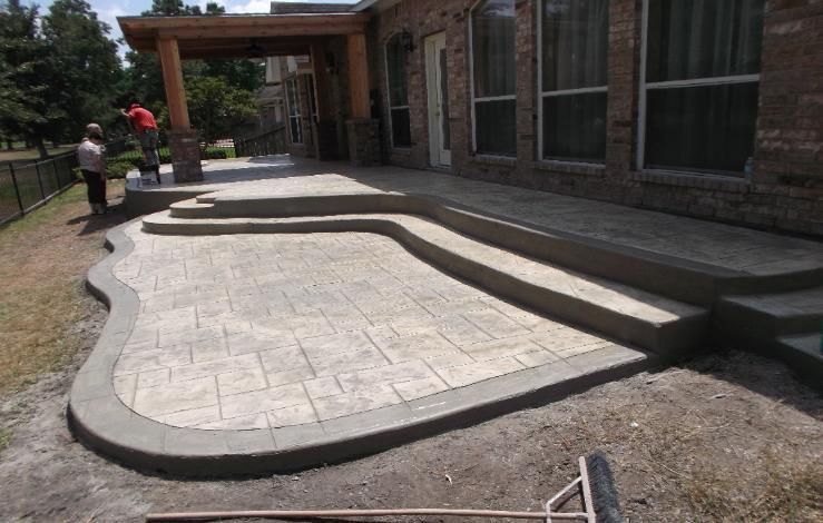 A patio is being built in front of a brick house