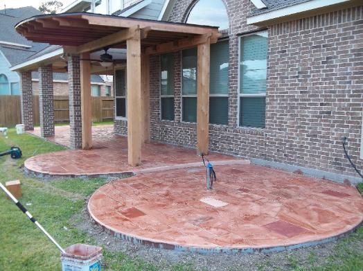 A patio is being built in front of a brick house.
