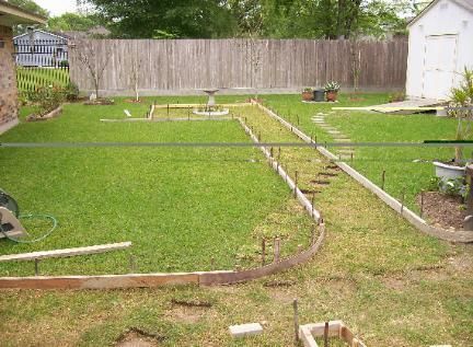 A backyard with a fence and a shed in the background