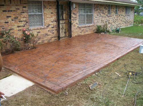 A brick house with a concrete patio in front of it