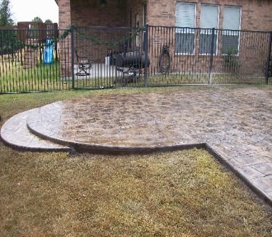 A brick house with a fence and a patio in front of it