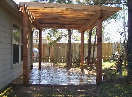A wooden pergola in the backyard of a house