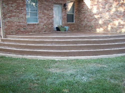 A brick house with a patio and stairs in front of it.