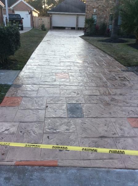 A concrete driveway with a yellow tape that says caution