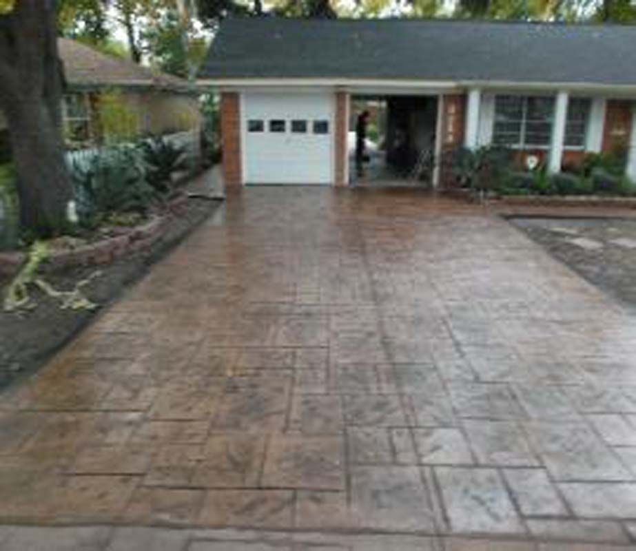 A concrete driveway leading to a house with a garage.