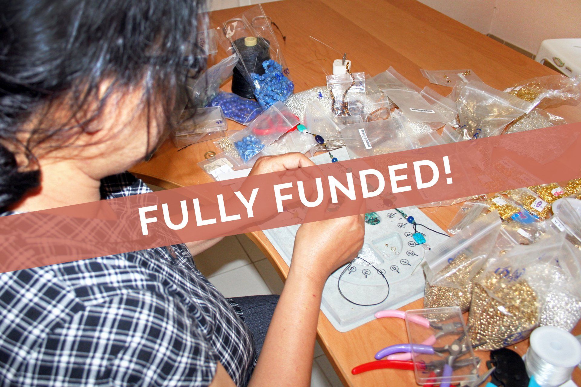 Person crafting jewelry at a table with materials, labeled 