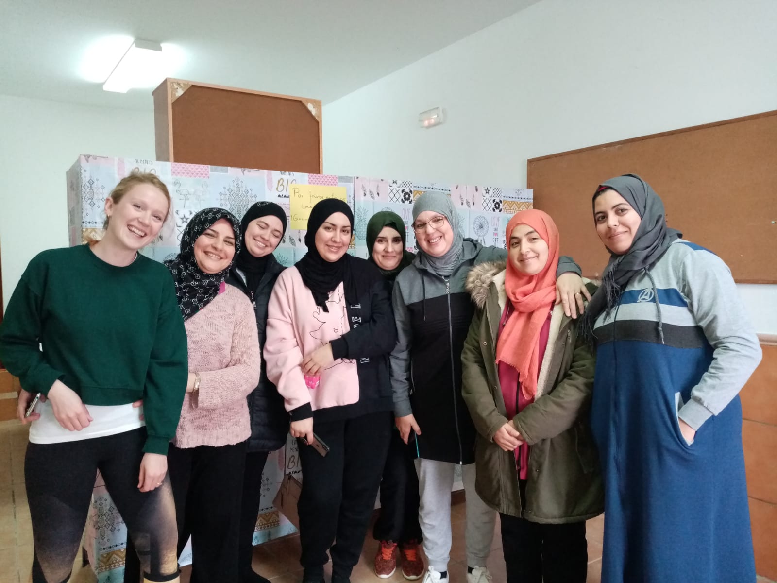 Group of people posing together indoors, smiling.